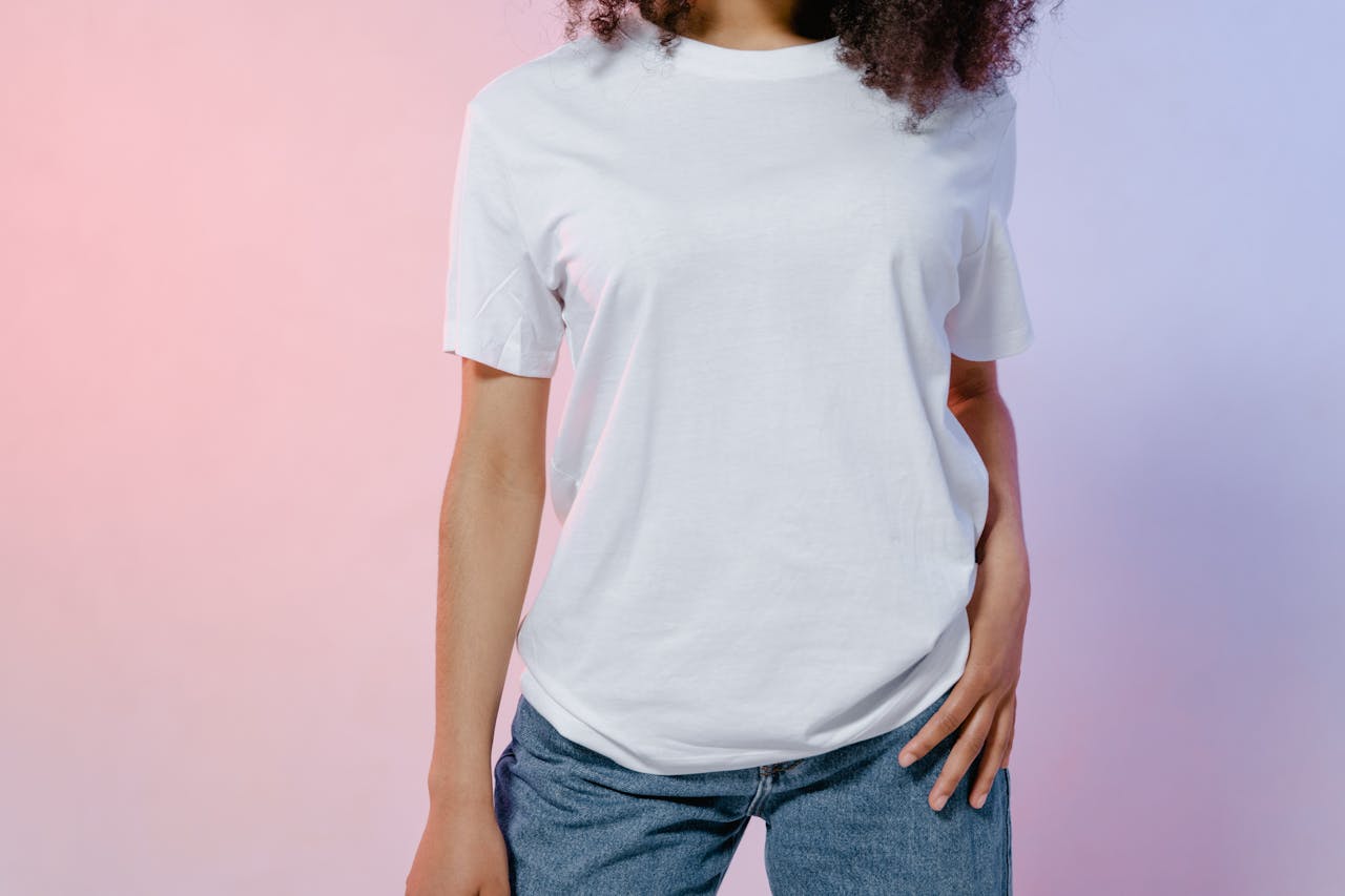 Close-up of a person in a white t-shirt and jeans, featuring modern fashion styling.