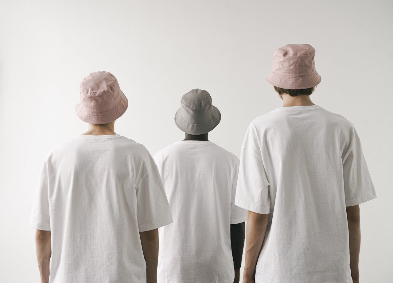 Mastering the First Impression: Your intriguing post title goes here Three men in white shirts and bucket hats facing away against a plain white backdrop.